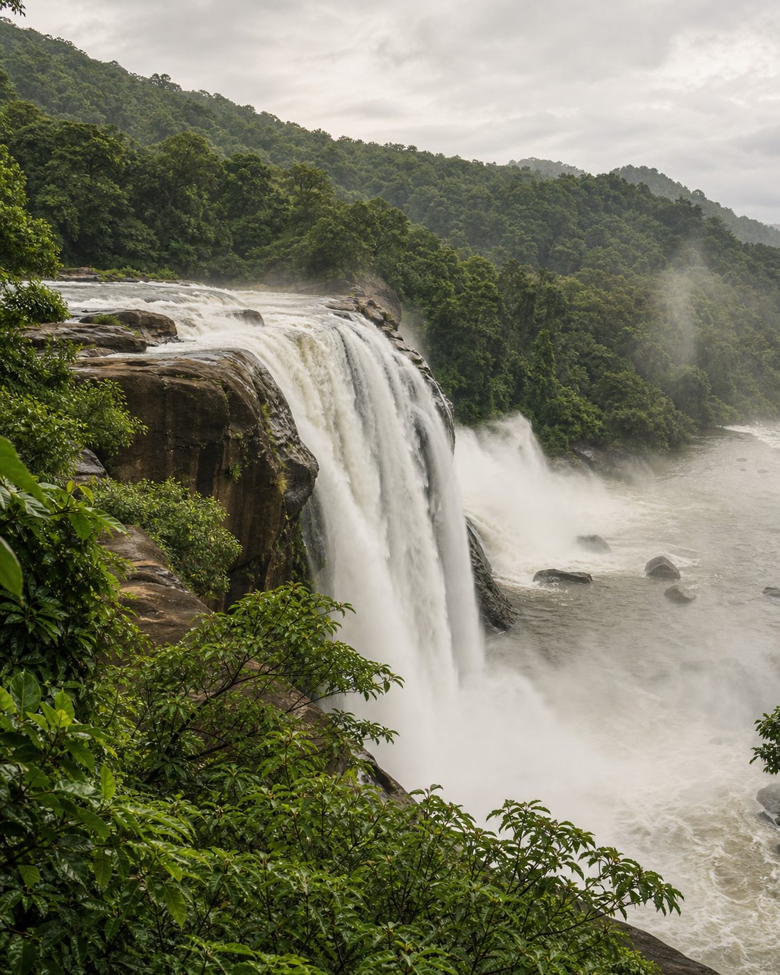 Athirapilly Waterfalls cascading through dense tropical forest in Kerala.